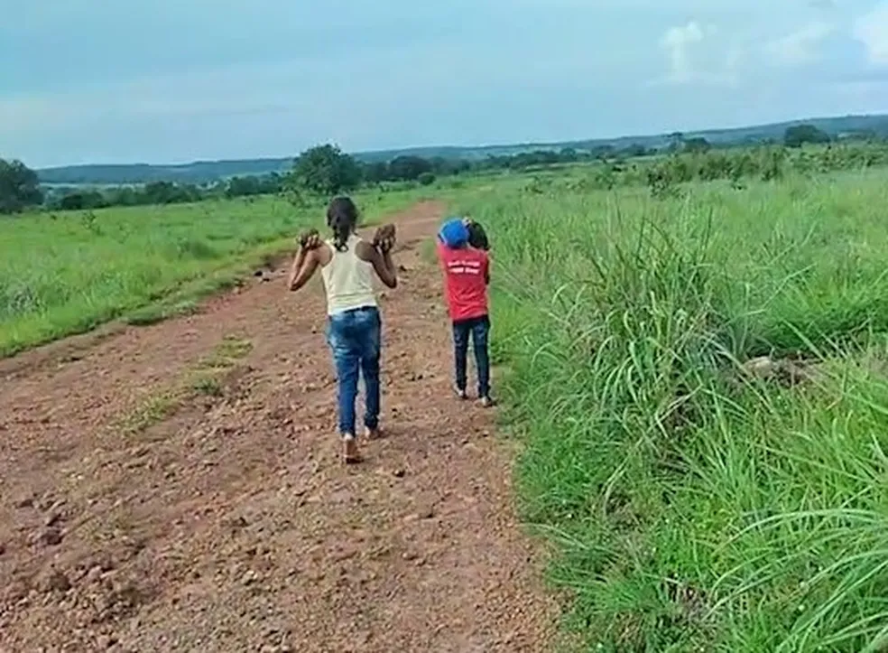 ‘Quero ir para escola’, diz criança que ajudou família a carregar pedras para tapar buracos de estrada por onde passa o ônibus escolar